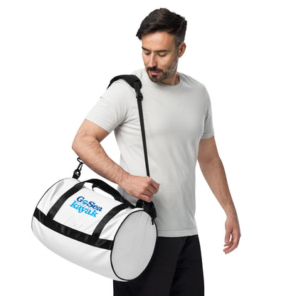 Gym Bag - White with black trim/detail - Side view, being worn over man's shoulder - With Go Sea Kayak Byron Bay logo on both sides - Genuine Byron Bay Merchandise | Produced by Go Sea Kayak Byron Bay 
