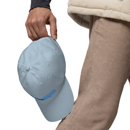  Unisex Cap - Light Blue - Man holding cap by back clasp, hanging down by legs - Go Sea Kayak logo on front  - Genuine Byron Bay Merchandise | Produced by Go Sea Kayak Byron Bay