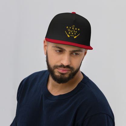  Flat Bill Cap - Black/Red - Front view being warn on man's head - With Yellow Byron Bay Surf Club logo on front - Genuine Byron Bay Merchandise | Produced by Go Sea Kayak Byron Bay 