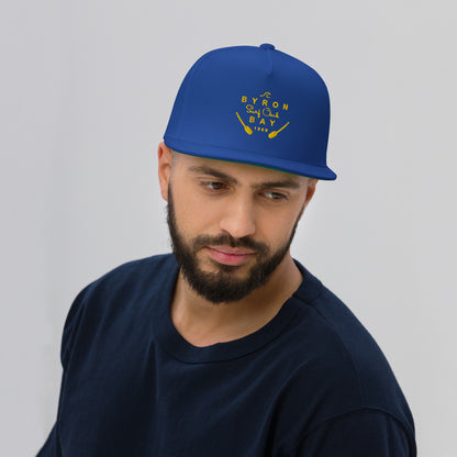  Flat Bill Cap - Royal Blue - Front view being warn on man's head - With Yellow Byron Bay Surf Club logo on front - Genuine Byron Bay Merchandise | Produced by Go Sea Kayak Byron Bay 