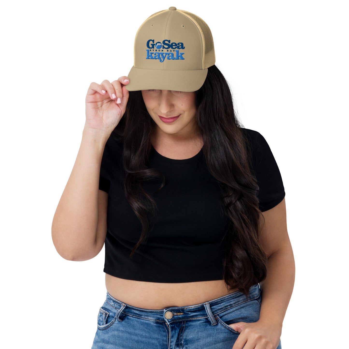  Trucker Cap - Khaki - Front view - being warn by woman with her head down and one hand holding the brim - Go Sea Kayak Byron Bay logo on front - Genuine Byron Bay Merchandise | Produced by Go Sea Kayak Byron Bay 