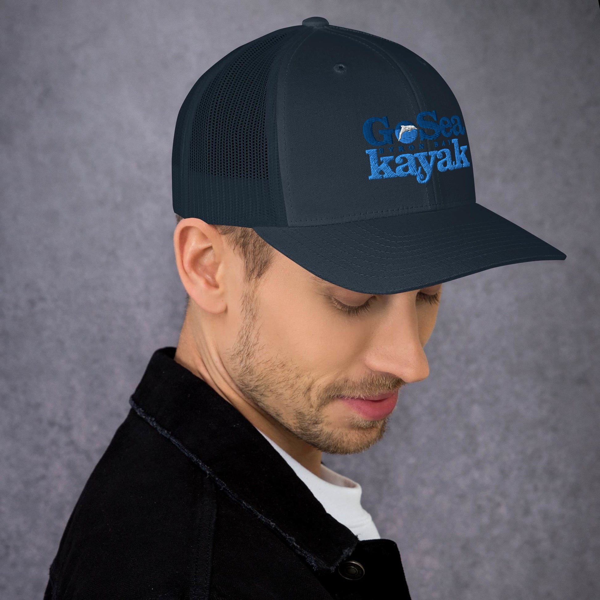  Trucker Cap - Navy - side view - being warn by man with his head down - Go Sea Kayak Byron Bay logo on front - Genuine Byron Bay Merchandise | Produced by Go Sea Kayak Byron Bay 