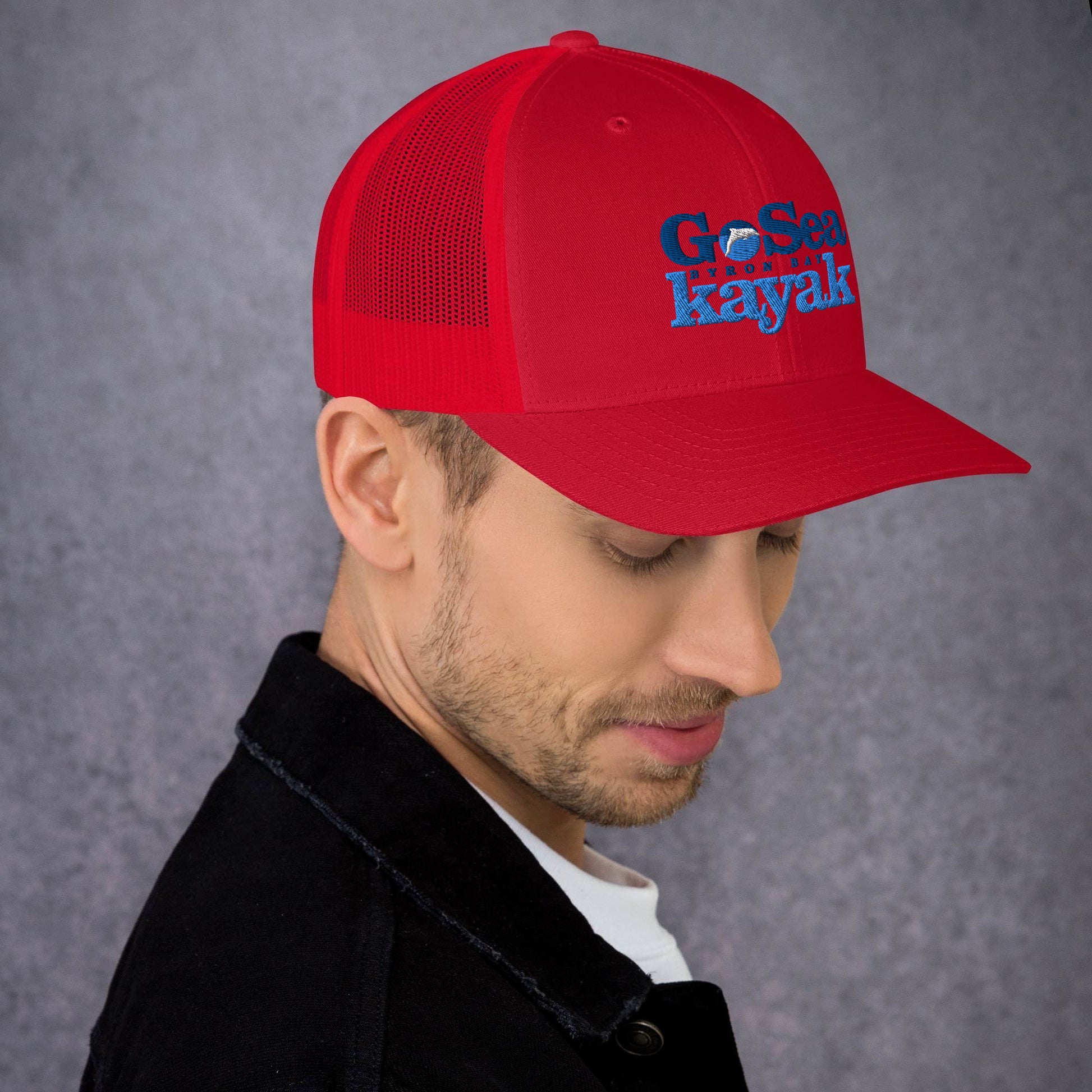  Trucker Cap - Red - Side view - being warn by man with his head down - Go Sea Kayak Byron Bay logo on front - Genuine Byron Bay Merchandise | Produced by Go Sea Kayak Byron Bay 