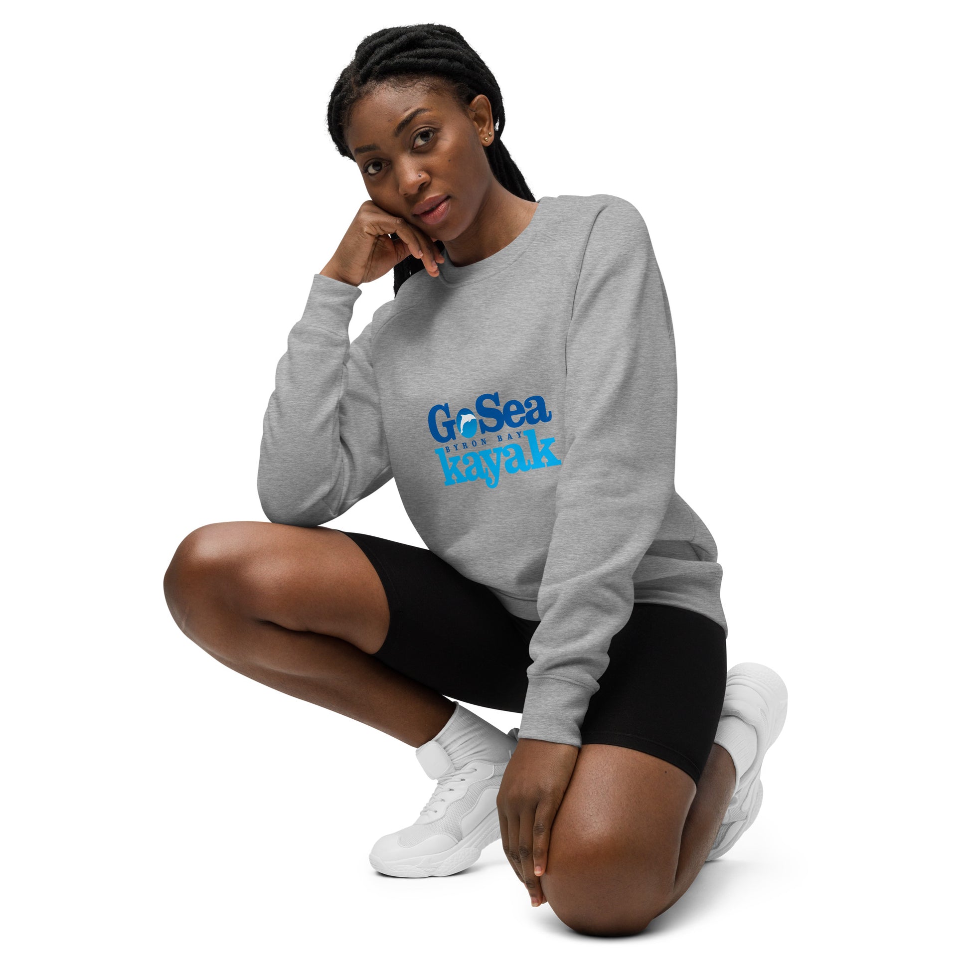  Unisex Sweatshirt - Grey Marle - Front view, being warn by woman crouching down with one knee up - Go Sea Kayak Byron Bay logo on front - Genuine Byron Bay Merchandise | Produced by Go Sea Kayak Byron Bay 