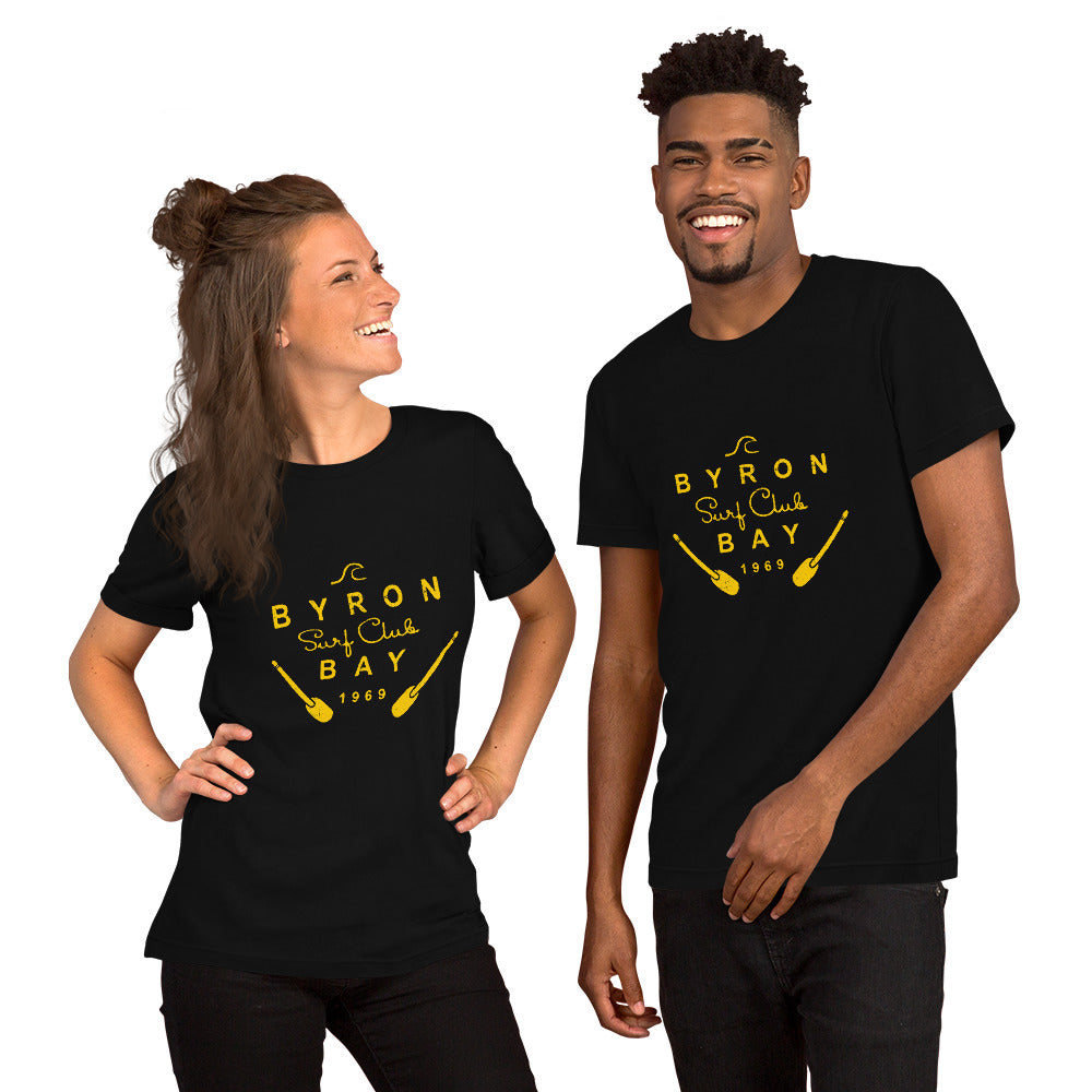  Unisex T-Shirt - Black - Front view, on woman and man standing next to eachother - Byron Bay Surf Club logo on front - Genuine Byron Bay Merchandise | Produced by Go Sea Kayak Byron Bay 