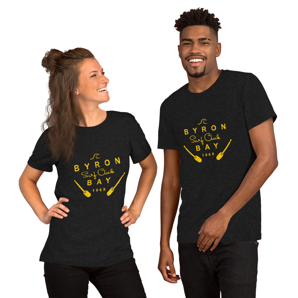  Unisex T-Shirt - Black Heather - Front view, on woman and man standing next to eachother - Byron Bay Surf Club logo on front - Genuine Byron Bay Merchandise | Produced by Go Sea Kayak Byron Bay 