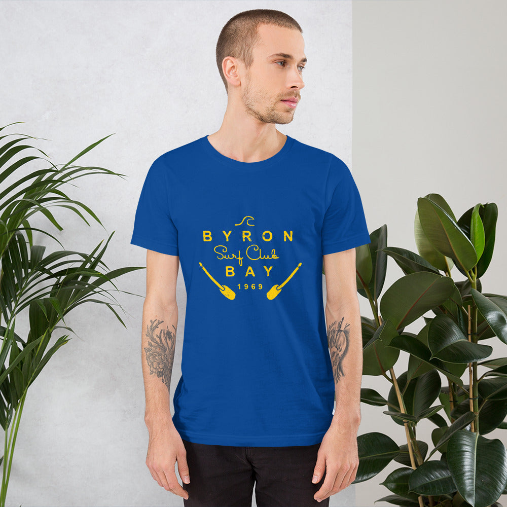  Unisex T-Shirt - True Royal Blue - Front view, on man with both arms by side - yellow Byron Bay Surf Club logo on front - Genuine Byron Bay Merchandise | Produced by Go Sea Kayak Byron Bay 