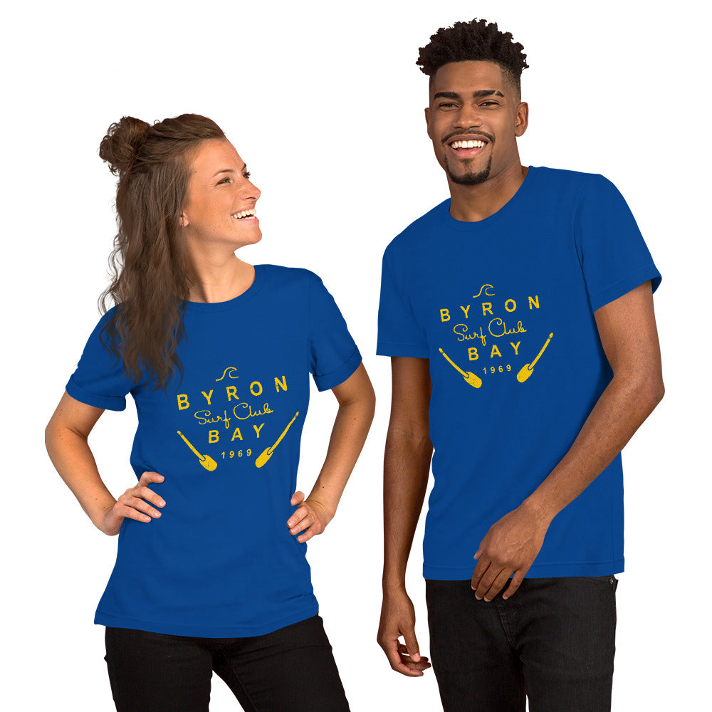  Unisex T-Shirt - True Royal Blue - Front view, on woman and man standing next to eachother - yellow Byron Bay Surf Club logo on front - Genuine Byron Bay Merchandise | Produced by Go Sea Kayak Byron Bay 