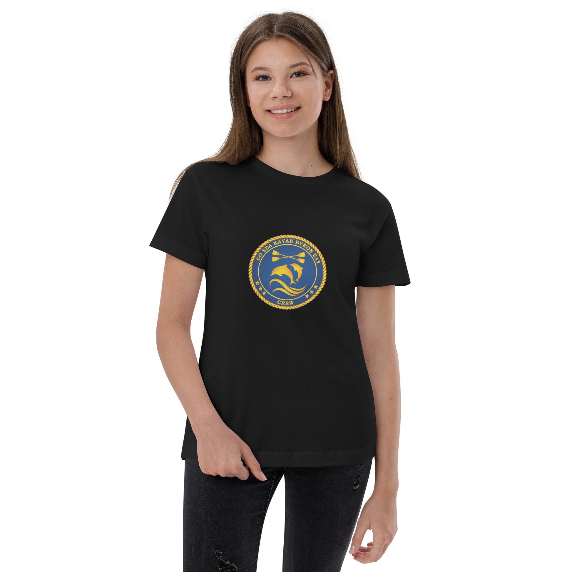  Kids T-Shirt - Black  - Front view, being warn on a girl standing with one hand grabing the bottom of the tee - Go Sea Kayak Byron Bay Crew (issue 2018-2019) logo on front - Genuine Byron Bay Merchandise | Produced by Go Sea Kayak Byron Bay 