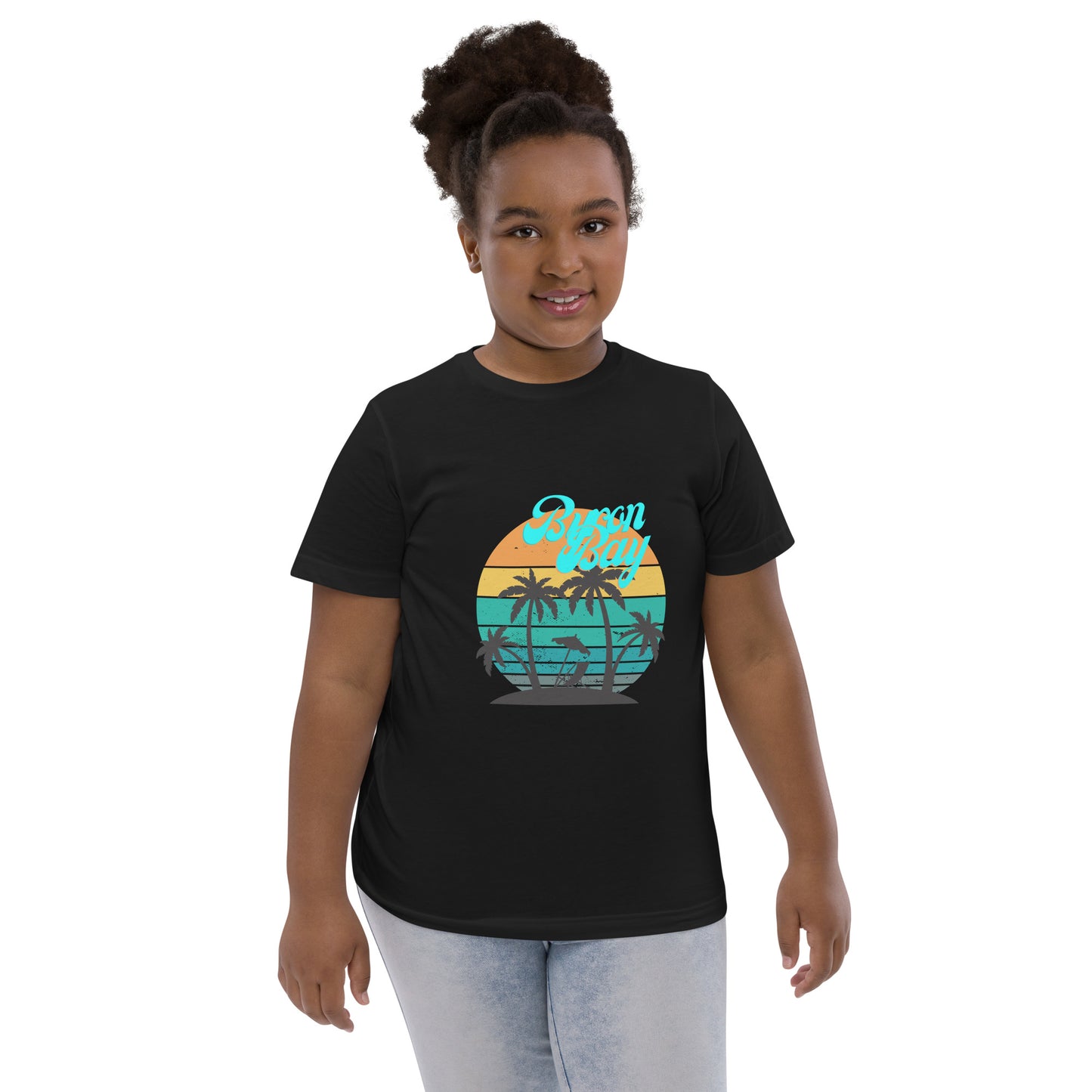  Kids T-Shirt - Black  - Front view, being warn on a girl standing with her arms by her side - Byron Bay design on front - Genuine Byron Bay Merchandise | Produced by Go Sea Kayak Byron Bay 