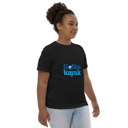  Kids T-Shirt - Black  - side view, being warn on a girl standing with her arms by her side - Go Sea Kayak Byron Bay logo on front - Genuine Byron Bay Merchandise | Produced by Go Sea Kayak Byron Bay 