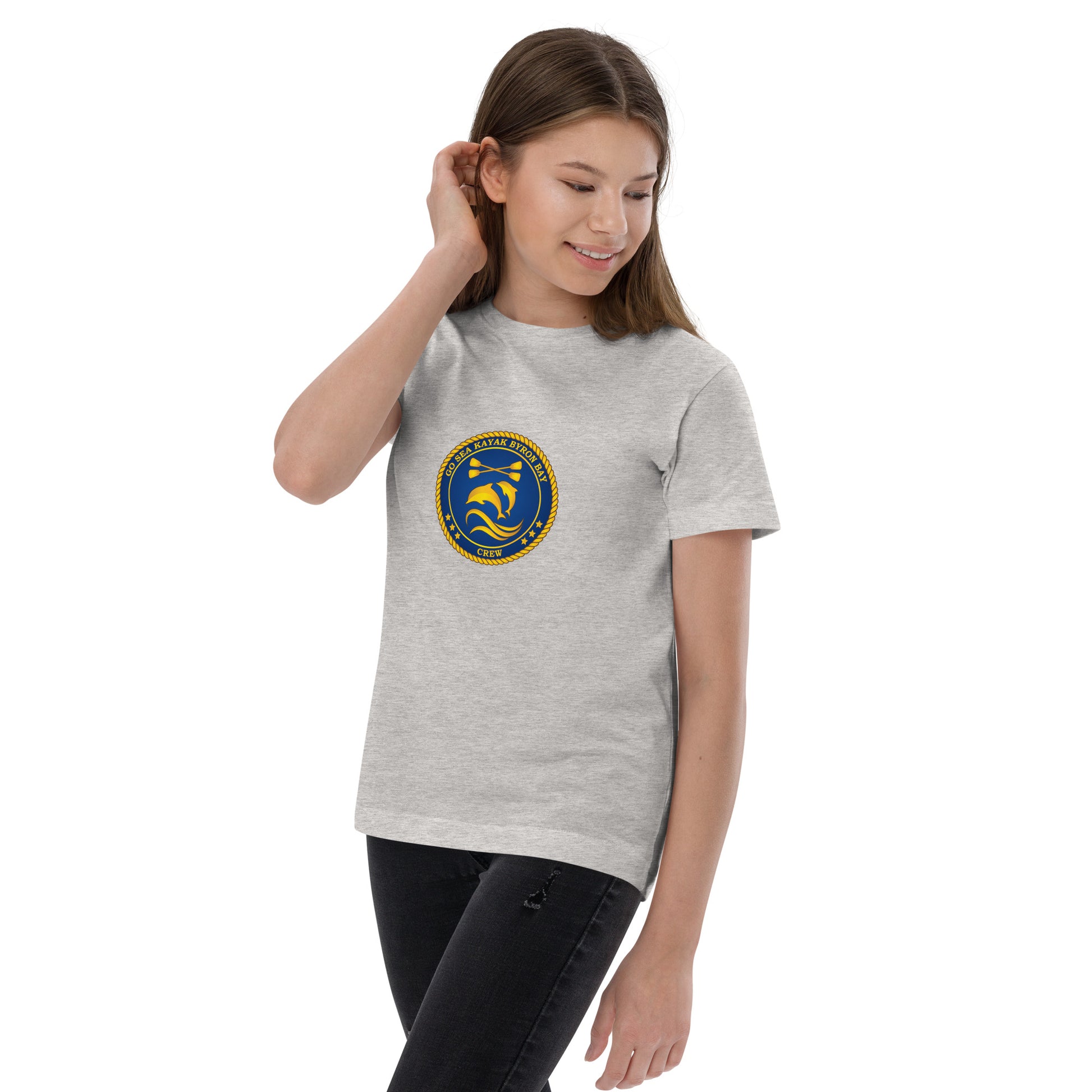  Kids T-Shirt - Natural / Heather colour - Being warn on girl standing one hand pushing hair behind ear - Go Sea Kayak Byron Bay Crew (issue 2018-2019) logo on front - Genuine Byron Bay Merchandise | Produced by Go Sea Kayak Byron Bay 