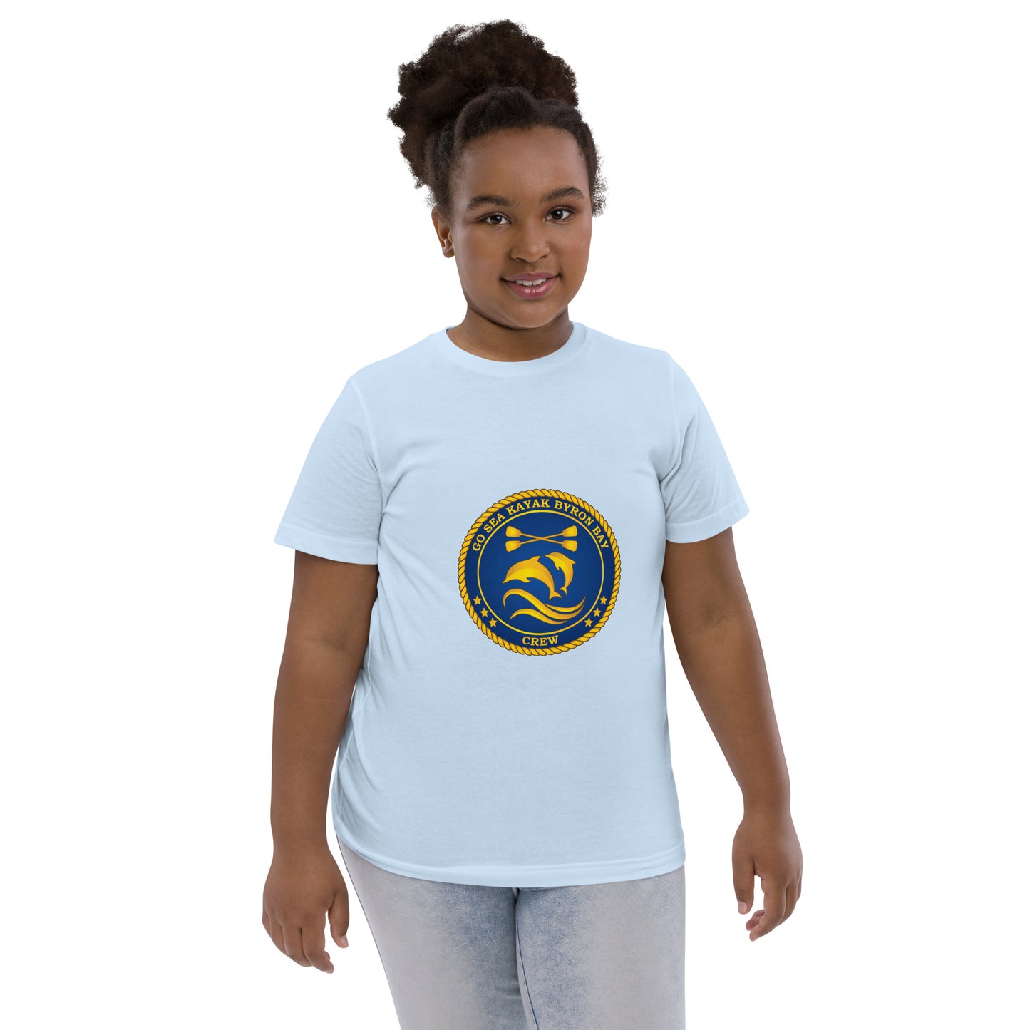  Kids T-Shirt - Light Blue - Front view, being warn on a girl standing with her arms by her side - Go Sea Kayak Byron Bay Crew (issue 2018-2019) logo on front - Genuine Byron Bay Merchandise | Produced by Go Sea Kayak Byron Bay 