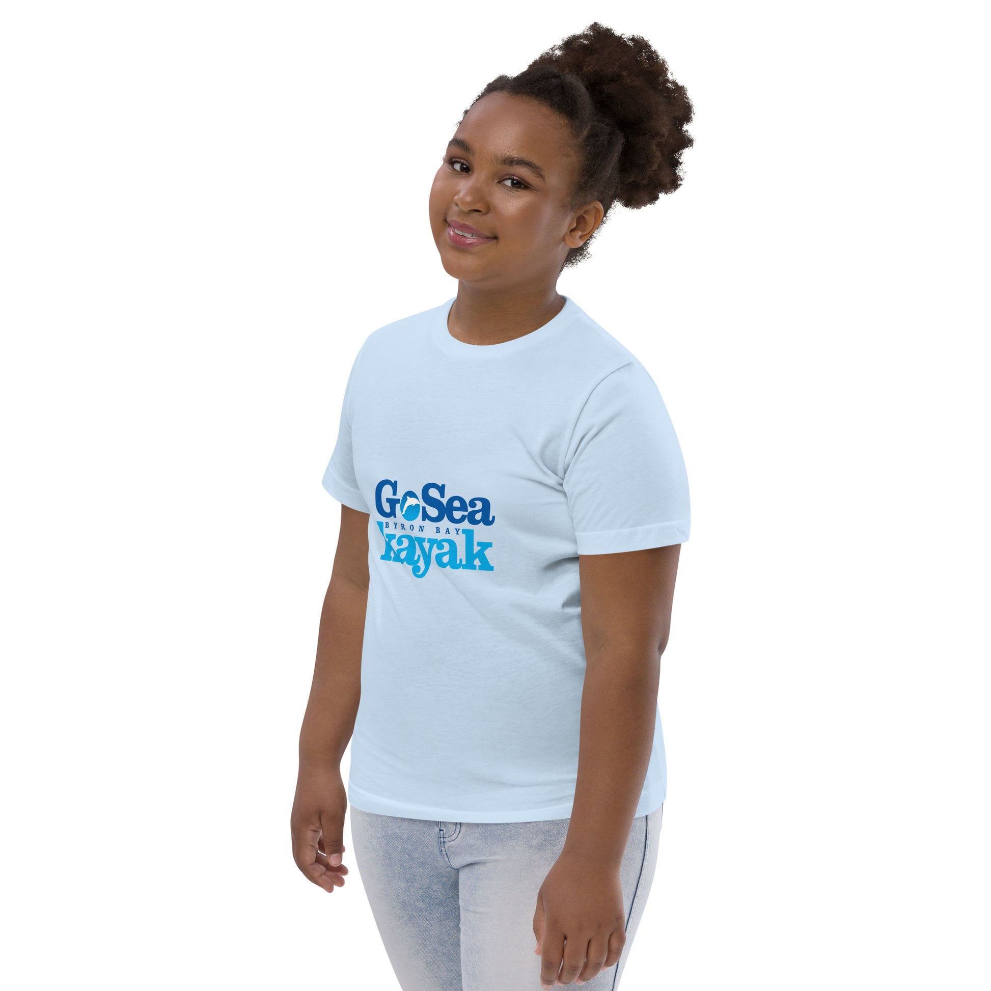  Kids T-Shirt - Light Blue - Side view, being warn on a girl standing with her arms by her side - Go Sea Kayak Byron Bay logo on front - Genuine Byron Bay Merchandise | Produced by Go Sea Kayak Byron Bay 